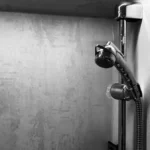 Duschkopf mit flexibler Handbrause und verchromtem Schlauch in einem modernen Duschbereich.